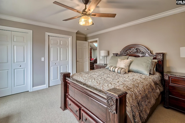 bedroom featuring light carpet, ceiling fan, ornamental molding, and multiple closets