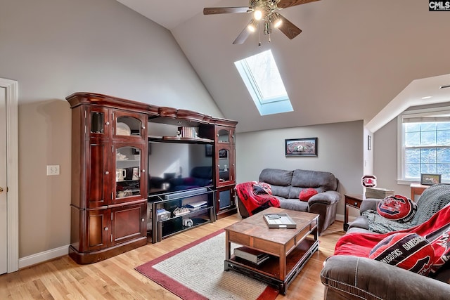 living room with ceiling fan, vaulted ceiling with skylight, and light hardwood / wood-style flooring