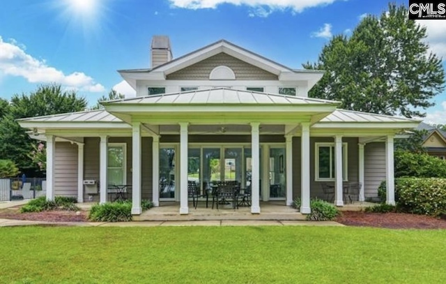 rear view of property with a yard and covered porch