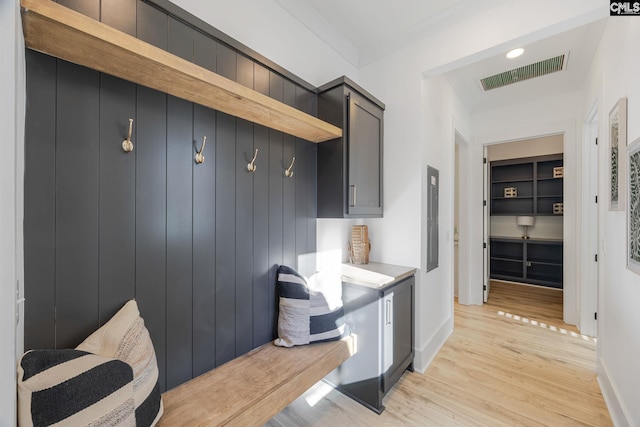 mudroom featuring electric panel and light hardwood / wood-style floors