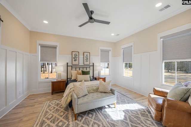 bedroom with ornamental molding, ceiling fan, and light wood-type flooring