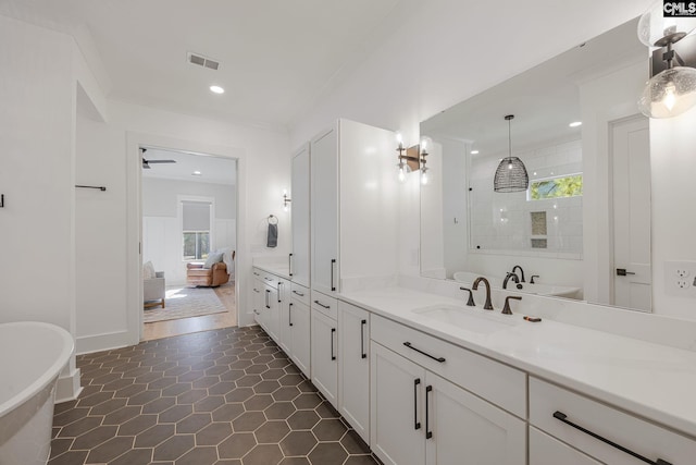 bathroom with vanity, a washtub, and crown molding