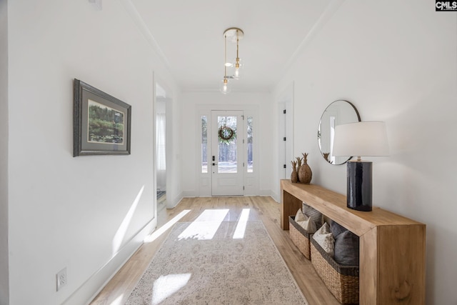 entryway featuring ornamental molding and light hardwood / wood-style floors