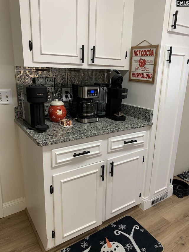 kitchen featuring white cabinetry, dark stone counters, and light hardwood / wood-style floors