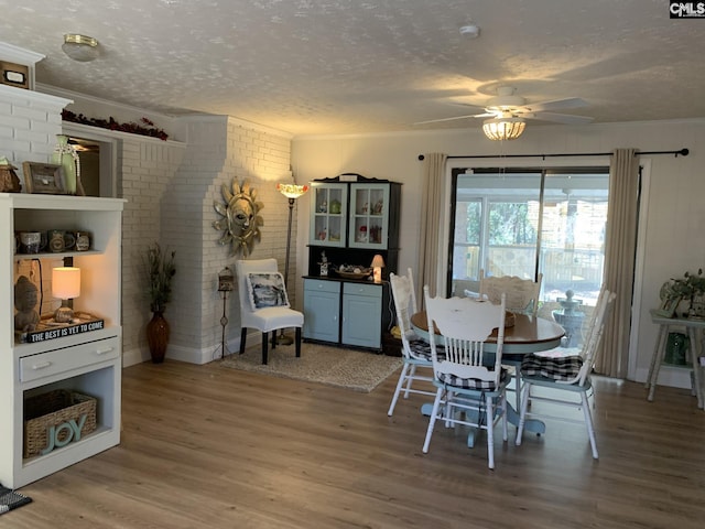 dining area with crown molding, wood-type flooring, and a textured ceiling