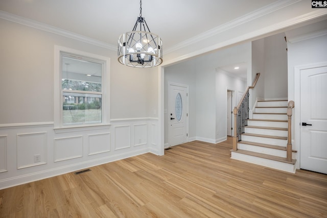 entrance foyer featuring an inviting chandelier, crown molding, and light hardwood / wood-style floors