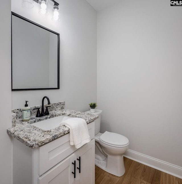 bathroom featuring vanity, hardwood / wood-style floors, and toilet