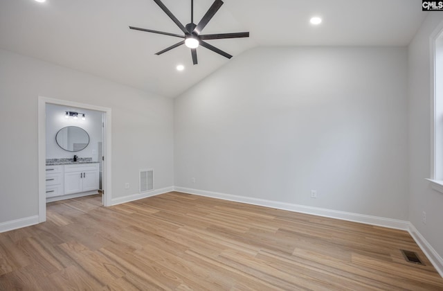 unfurnished bedroom with ensuite bathroom, sink, vaulted ceiling, light wood-type flooring, and ceiling fan