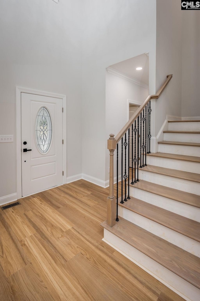 foyer with hardwood / wood-style flooring and ornamental molding