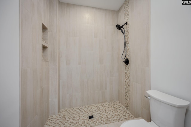 bathroom featuring toilet and a tile shower