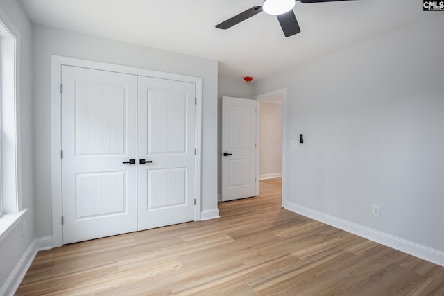 unfurnished bedroom featuring ceiling fan, a closet, and light hardwood / wood-style flooring