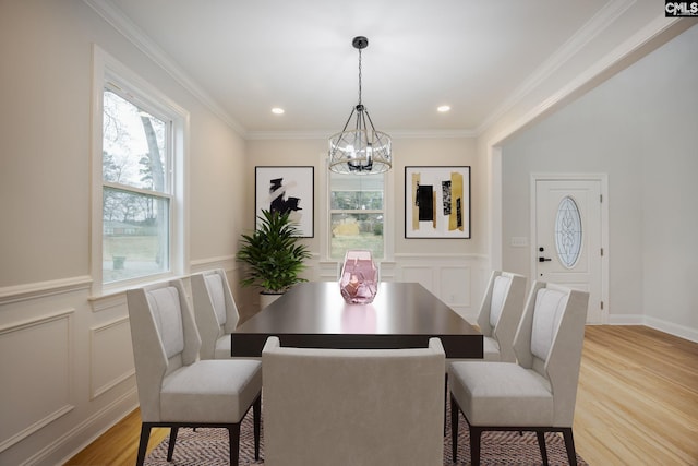 dining area featuring an inviting chandelier, crown molding, and light hardwood / wood-style flooring