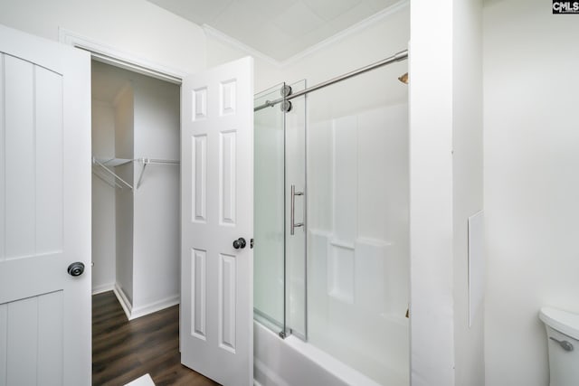 bathroom with hardwood / wood-style flooring, ornamental molding, shower / bath combination with glass door, and toilet