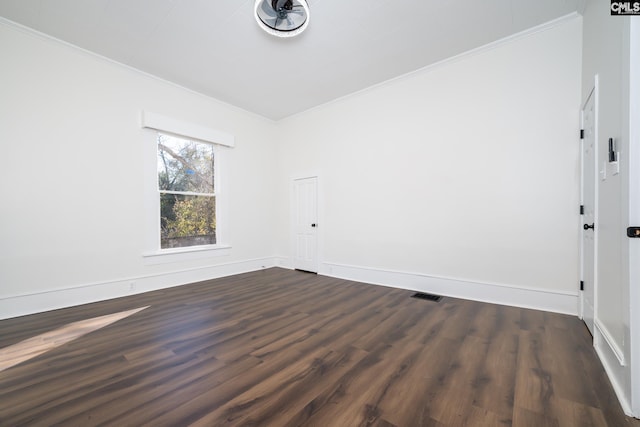 empty room with crown molding and dark wood-type flooring