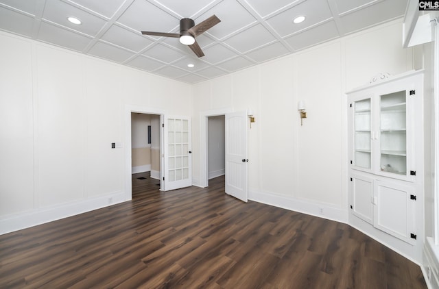 unfurnished room with coffered ceiling, dark wood-type flooring, and ceiling fan