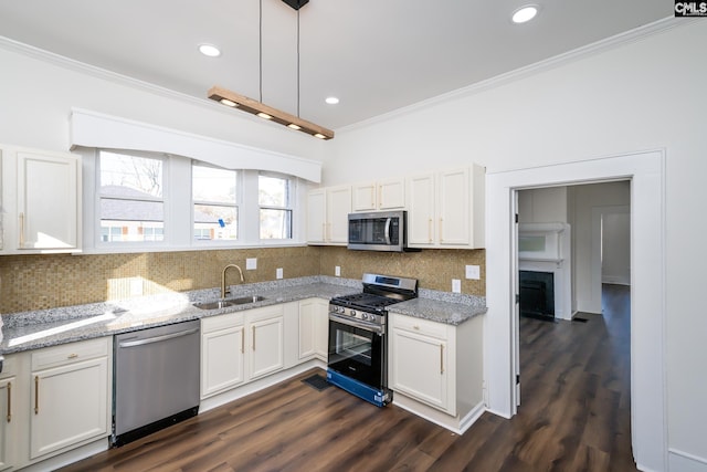 kitchen with pendant lighting, white cabinetry, stainless steel appliances, and sink