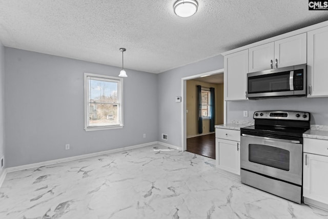 kitchen featuring hanging light fixtures, appliances with stainless steel finishes, and white cabinets