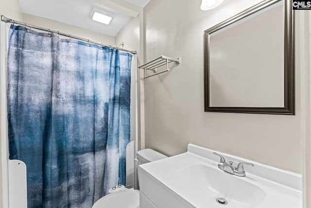 bathroom with walk in shower, vanity, and toilet