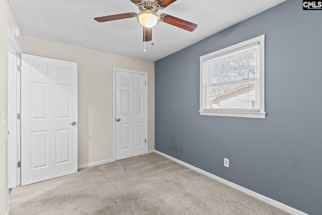 unfurnished bedroom featuring ceiling fan and light colored carpet