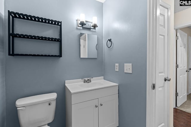 bathroom featuring vanity, hardwood / wood-style flooring, and toilet