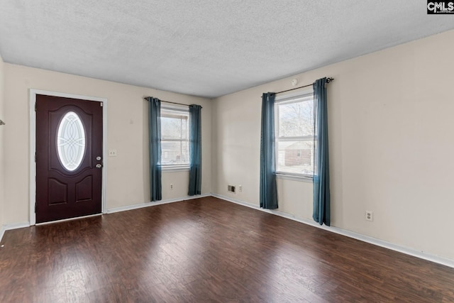 foyer entrance featuring dark wood-type flooring and a textured ceiling