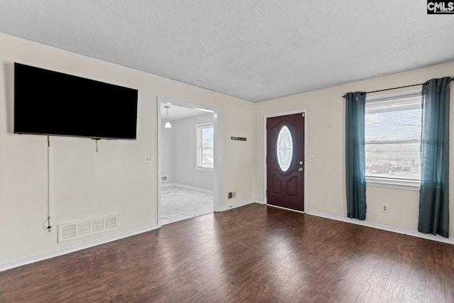 foyer entrance with hardwood / wood-style flooring and a textured ceiling