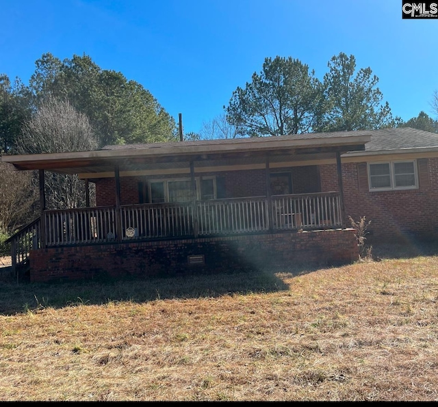 ranch-style house with covered porch and a front yard