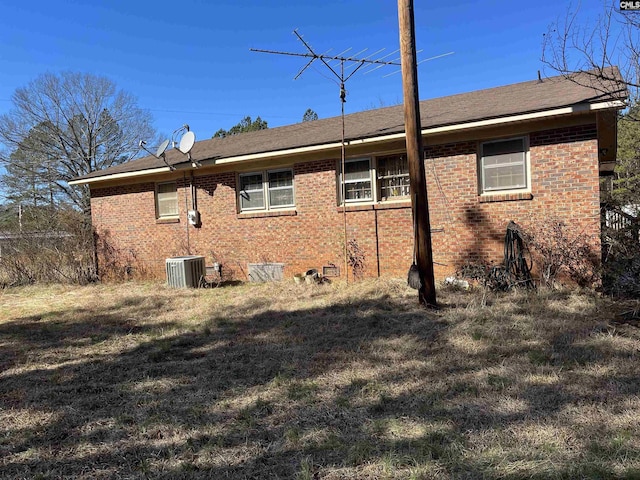 view of home's exterior with central AC and a lawn