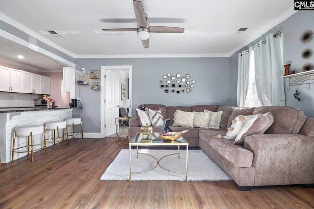 living room featuring ceiling fan, ornamental molding, and dark hardwood / wood-style flooring