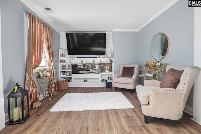 living room featuring hardwood / wood-style flooring and ornamental molding