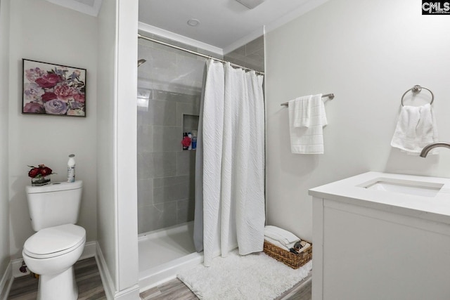 bathroom with hardwood / wood-style floors, vanity, curtained shower, and toilet