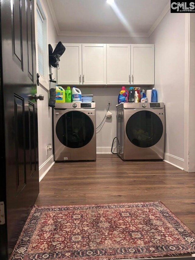 washroom featuring cabinets, ornamental molding, dark hardwood / wood-style flooring, and washer and clothes dryer