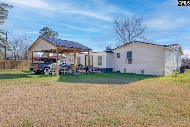 rear view of house featuring a yard and central AC unit