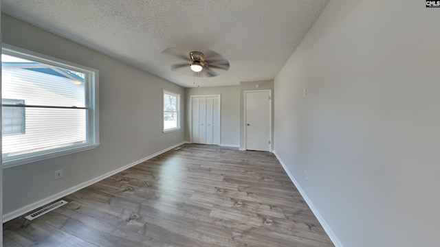 unfurnished bedroom with ceiling fan, a textured ceiling, and light hardwood / wood-style flooring