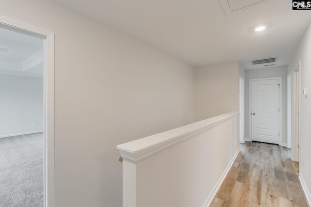 corridor featuring light wood finished floors, baseboards, visible vents, an upstairs landing, and recessed lighting