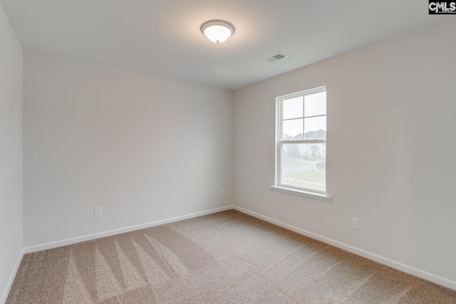 carpeted spare room featuring visible vents and baseboards