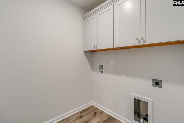 laundry area featuring hookup for a washing machine, cabinet space, electric dryer hookup, light wood-type flooring, and baseboards