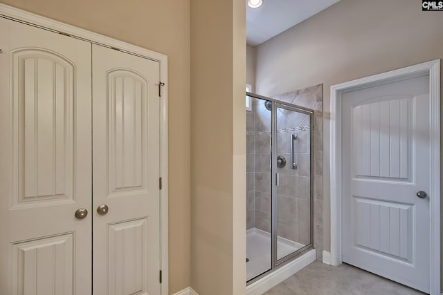 bathroom with tile patterned flooring and a shower with shower door