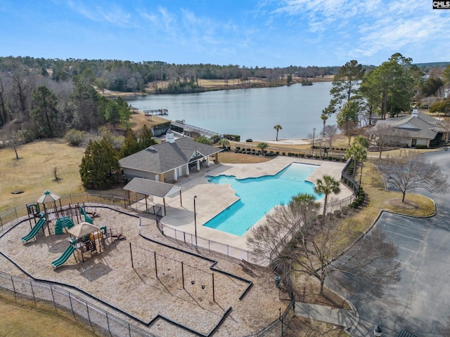 view of swimming pool featuring a water view, a playground, and a patio