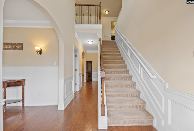 stairway with crown molding and hardwood / wood-style floors