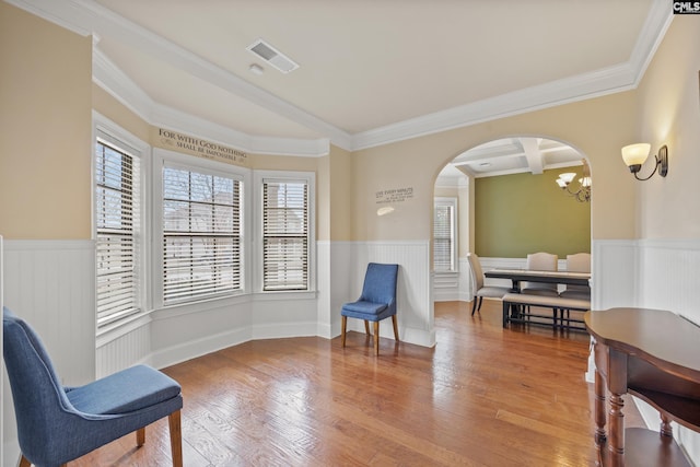 sitting room featuring hardwood / wood-style flooring, coffered ceiling, beam ceiling, and crown molding