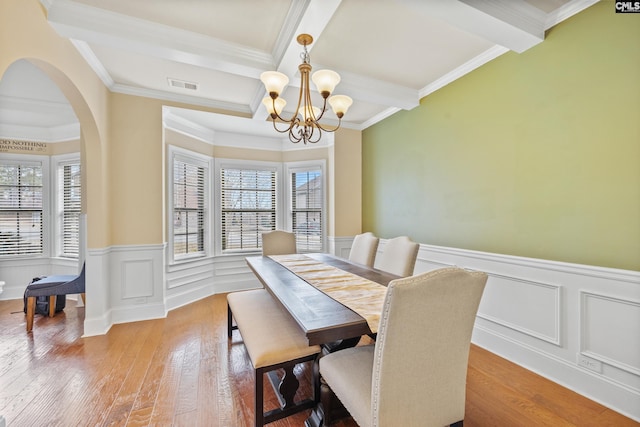 dining area with beamed ceiling, wood-type flooring, and a wealth of natural light