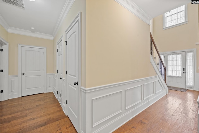 entryway featuring ornamental molding and wood-type flooring