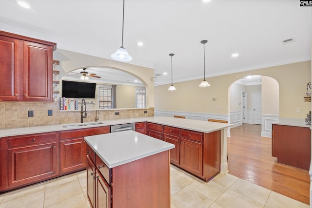 kitchen with sink, ceiling fan, hanging light fixtures, a kitchen island, and kitchen peninsula