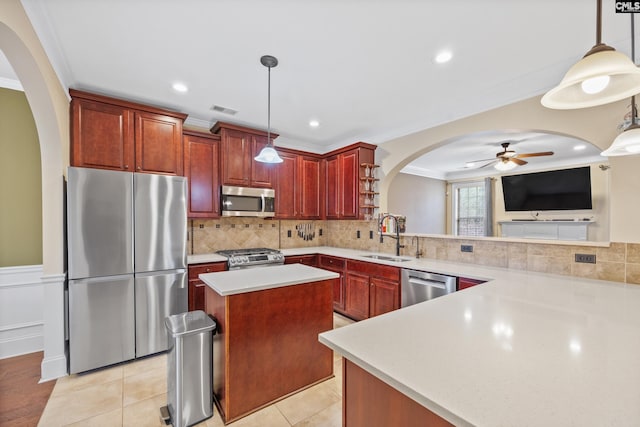 kitchen with pendant lighting, stainless steel appliances, a center island, and sink