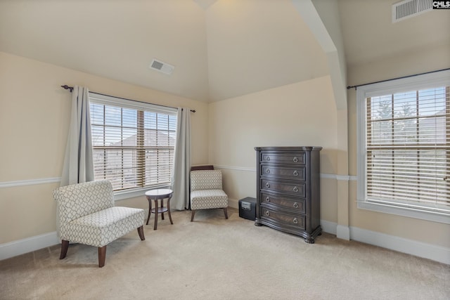 sitting room with light colored carpet and high vaulted ceiling