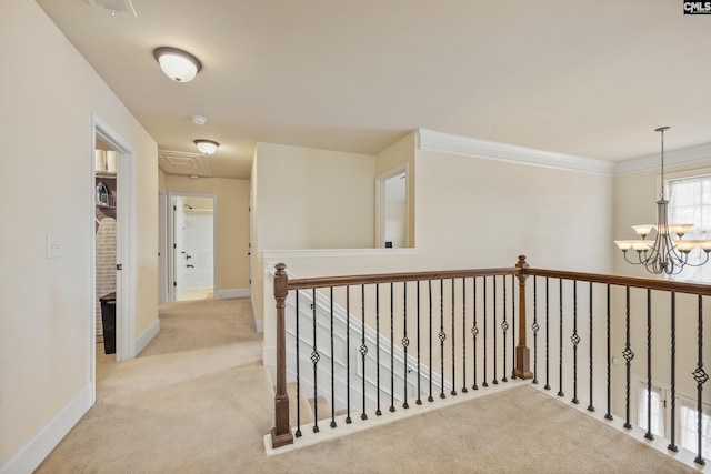 hall featuring ornamental molding, light colored carpet, and a chandelier