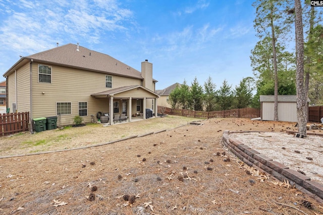 back of property with a patio and a storage unit