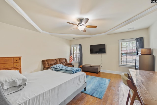 bedroom with crown molding, light hardwood / wood-style flooring, and ceiling fan