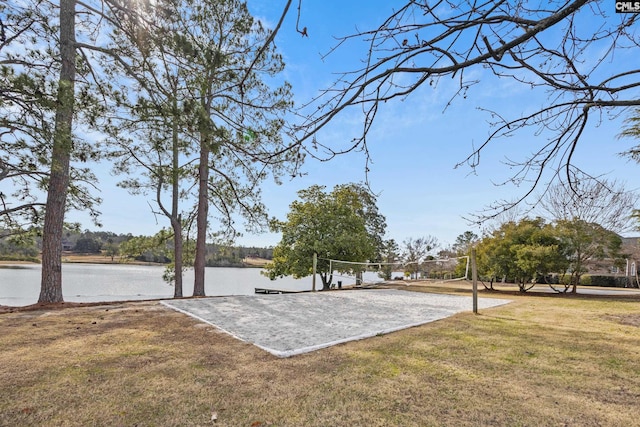 view of property's community featuring a water view, volleyball court, and a lawn